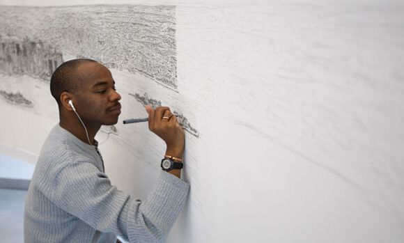 Man drawing a city landscape on a wall