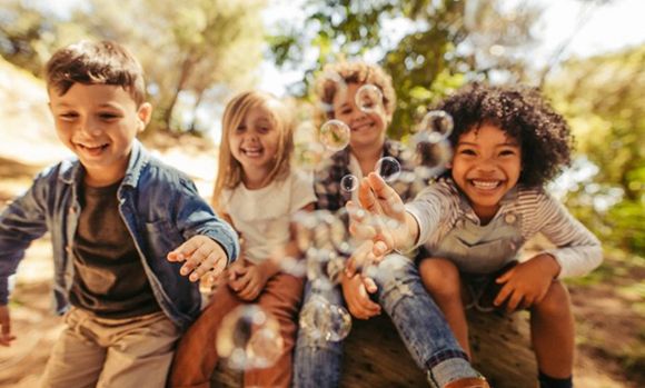 Children laughing and playing with bubbles