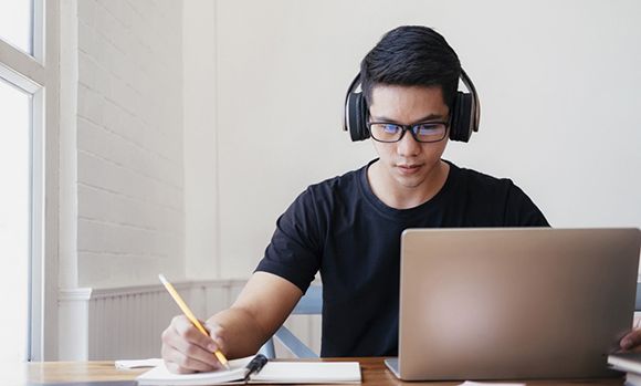 Teenager studying with headphones on